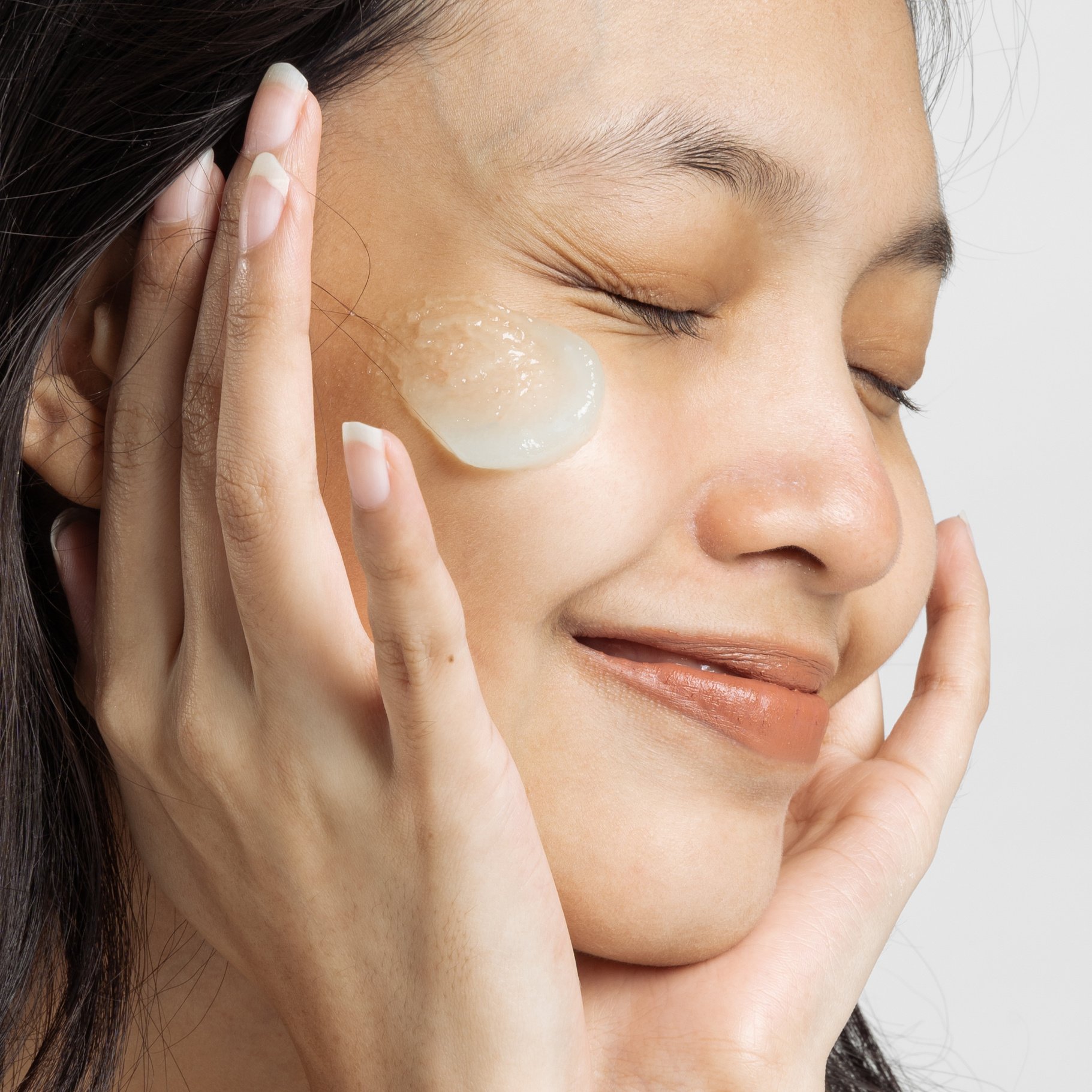 Closeup Portrait of Smiling Woman with Moisturizer